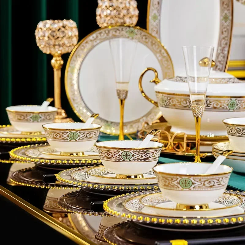 An elegant table setting featuring ornate gold and patterned dinnerware, including bowls, plates, and decorative elements, against a dark green backdrop.